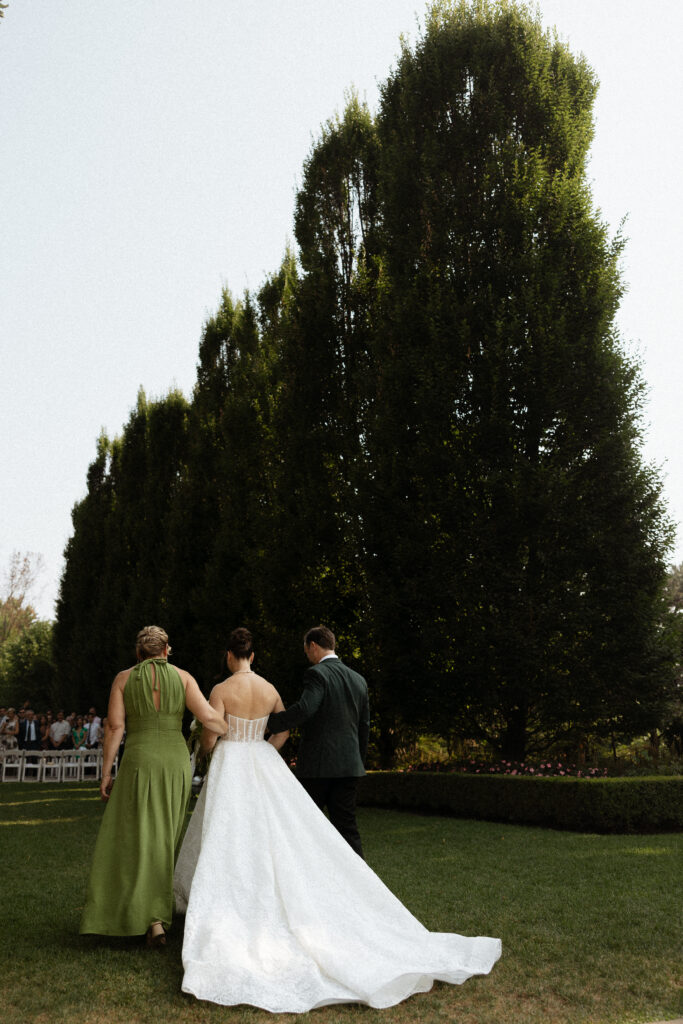 Graydon Hall Manor wedding ceremony in Toronto gardens, bride walking down the aisle with parents